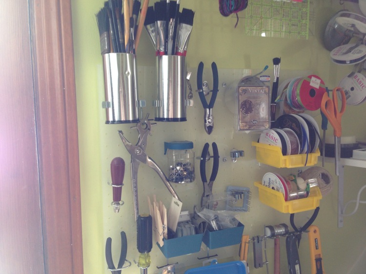 pegboard and paintbrushes and other tools